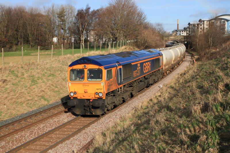 66737 in the sun: 66737 passing Peffermill Playing fields on 6S45 09.02 North Blyth to Fort William on 25-02-2012 running on a revised time from Millerhill which caught my pet cloud out which was approaching. Photo of 66737 in the sun