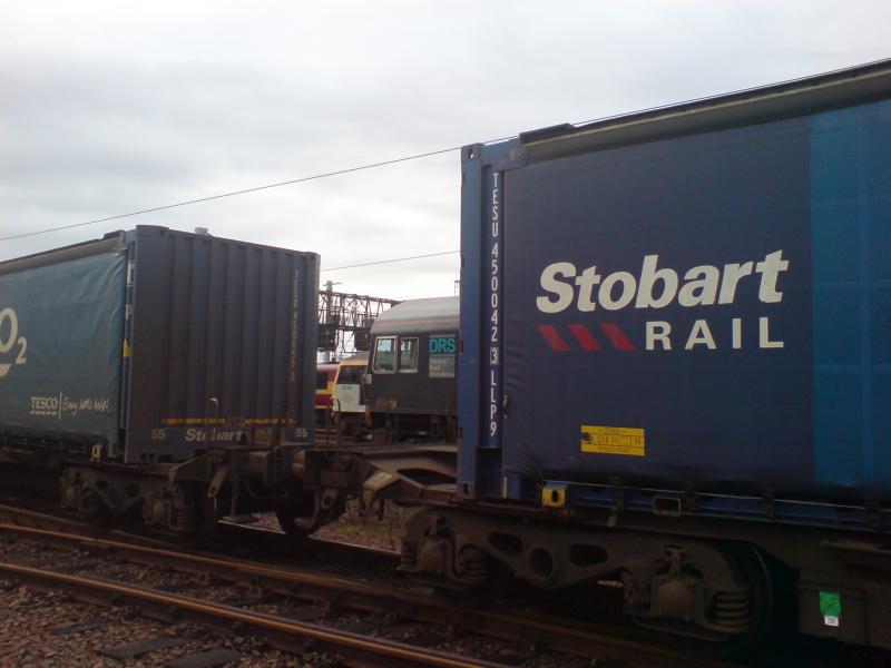 Stobart Rail at Mossend: The cabs of 66 413 and 92 003 can be seen between the wagons of the Stobart Rail Tesco Express train at Mossend Yard (29.01.12). Photo of Stobart Rail at Mossend