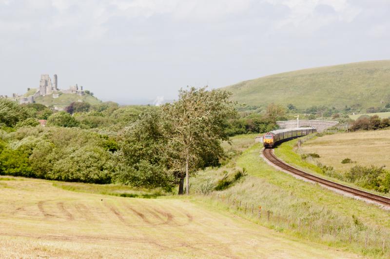 VSOE Pullmans: Having crossed a service train at Corfe Castle, the railtour heads out over Corfe Common towards the line's summit at Afflington. The ruins of Corfe Castle are to the left. Photo of VSOE Pullmans