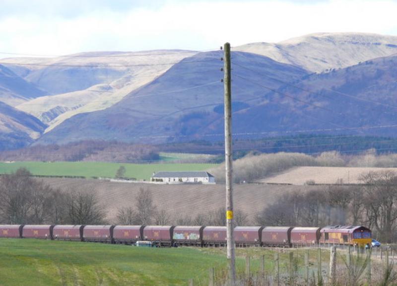 6G18: The very first train of HTA coal trucks approaching Kincardine with the sun picking out the Ochil Hills.
Pity about the graffiti. Photo of 6G18