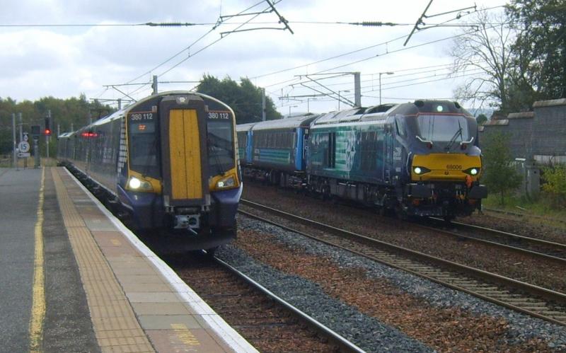The New Order at Carstairs.22nd September2014: 380112 on an Edinburgh to Ayr service arrives Carstairs passing 68006 in the DPL with ecs move in connection with forthcomimg golfs Ryder Cup at Gleneagles. Photo of The New Order at Carstairs.22nd September2014
