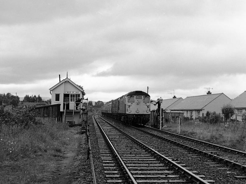 26014: 26014 exchanges single line tokens at Muir of Ord on 1 July 1980 as it passes with the 11.05 Kyle of Lochalsh - Inverness. Photo of 26014