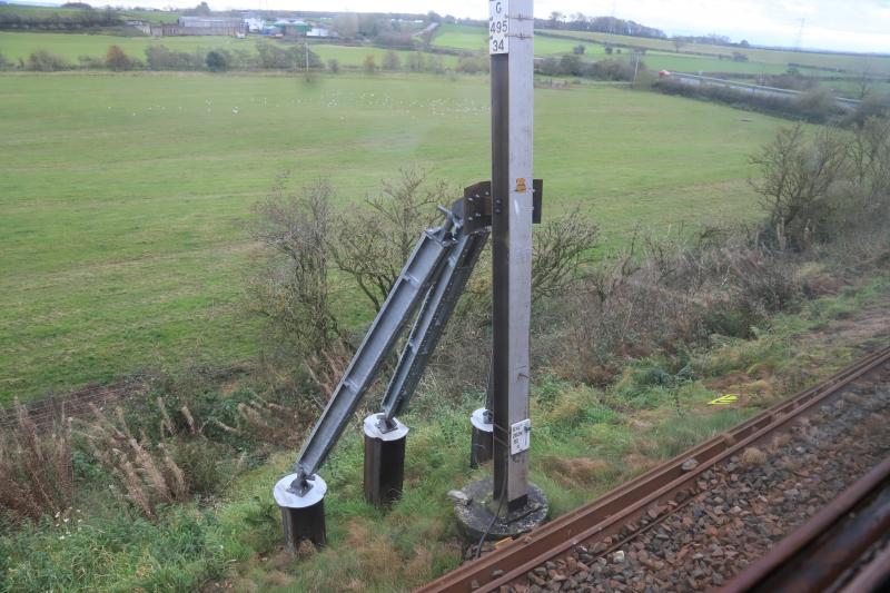 Supports for a Leaning Mast: Mast G495/34 in the Quintinshill area. The embankment must be weaker at this point to make the mast lean away from the rails. Taken from the stationary SRPS tour to York. Photo of Supports for a Leaning Mast