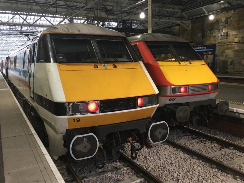 Past and Present: Representing the past - 91119 in nostalgic Intercity Swallow livery, and representing the present - 91108 in VTEC/LNER livery, standing side by side in Edinburgh Waverley platform 5 and 6, respectively. Photo of Past and Present