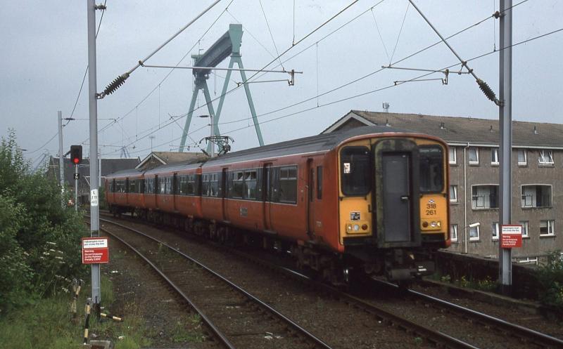 318261 at Port Glasgow 1994: 318261 approaches Port Glasgow with a service to Glasgow on 1 August 1994. Scott Lithgow's gantry crane was a distinctive feature of the skyline until demolished in 1997. Photo of 318261 at Port Glasgow 1994