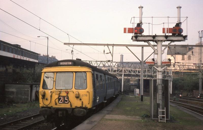 303078 at Bridgeton Central: 303078 arrives at Bridgeton on 15 October 1977. Bridgeton was one of the few places on the BR system where semaphore signals were used on an AC electrified line. Photo of 303078 at Bridgeton Central