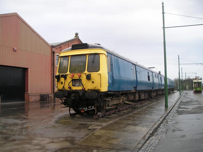 311103 at Summerlee Mid 2000s: 311103 sits at Summerlee following its repaint in BR Blue. The windows facing the street were mostly plated over to deter the locals from breaking them. Lanarkshire 53 is the tram in the background. Photo of 311103 at Summerlee Mid 2000s