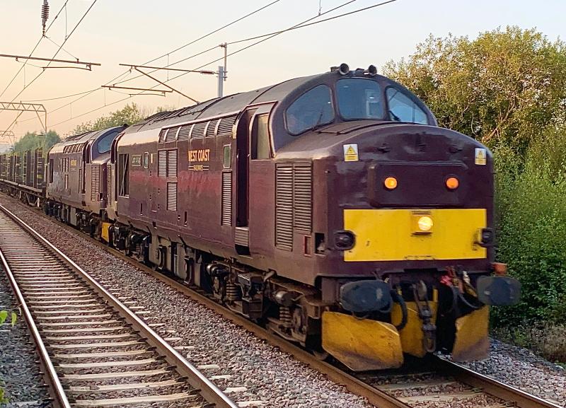 Logging Out: With the Timber Trials on the FNL coming to a close, West Coast Class 37s no. 37685 and 37668 fly past Coatbridge Central with the BTA wagons which were used for said trials, working 6Z37 from Inverness to Tees Yard. Photo of Logging Out