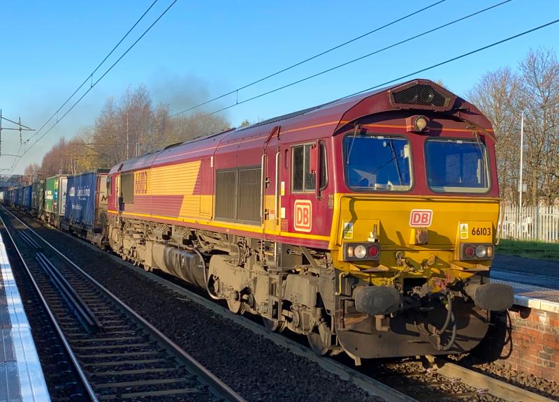 Sunny Shed: DB Cargo 66103 in unbranded EWS livery, is seen powering through Holytown working the 4M30 from Grangemouth to Daventry in early afternoon sunshine. Not a single cloud to be seen just then! Photo of Sunny Shed