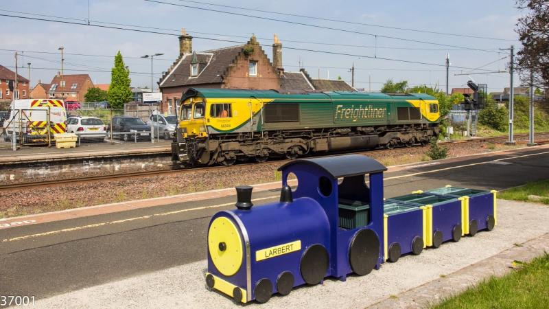 66504 on 0K87 at CofU: Freightliner 66504 enters the loop at Larbert with 0K87 Millerhill - Perth whilst carrying RILA route surveying equipment attached to the rear of the loco.
The local train waits patiently on the platform Photo of 66504 on 0K87 at CofU