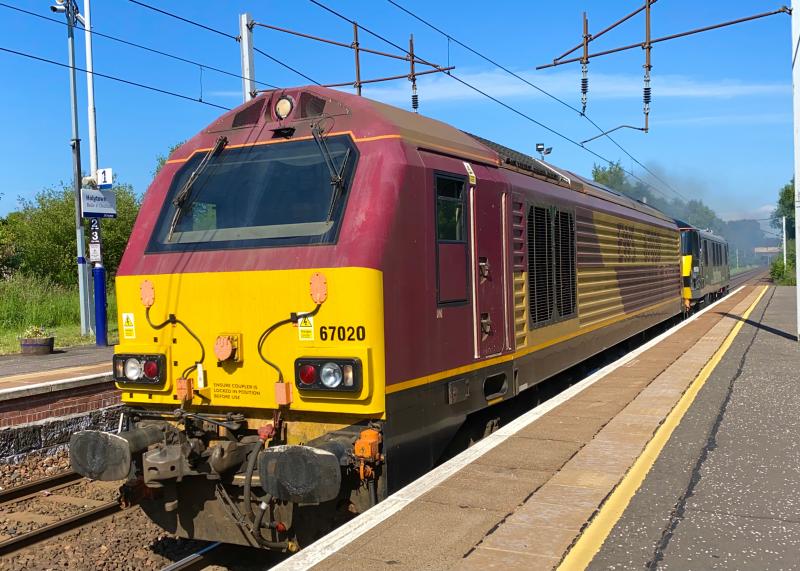 Backbone Behind: DB Cargo owned, EWS branded 67020 with a dead 90039 in tow clags quite nicely through Holytown working from Mossend to Crewe on a bright morning (22/06/2021) Photo of Backbone Behind