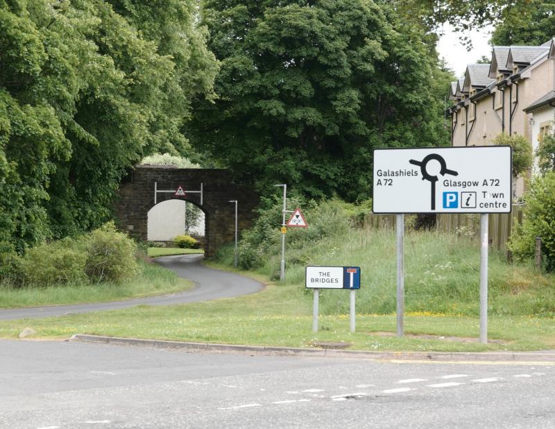 Peebles East: This view is along the route towards Galashiels, while the connecting line to Peebles West follows the main road to the right.
There is a partially filled underbridge & path. Photo of Peebles East