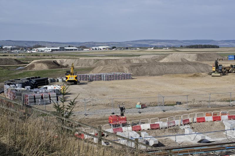 DALCROSS WIP LKG TO AIRPORT BUILDINGS 23.3.22.jpg: LIKE DYCE --THE AIRPORT BUILDINGS ARE SOME WAY FROM THE STATION SERVING IT.CAR PARK TO RIGHT OF JCB Photo of DALCROSS WIP LKG TO AIRPORT BUILDINGS 23.3.22.jpg