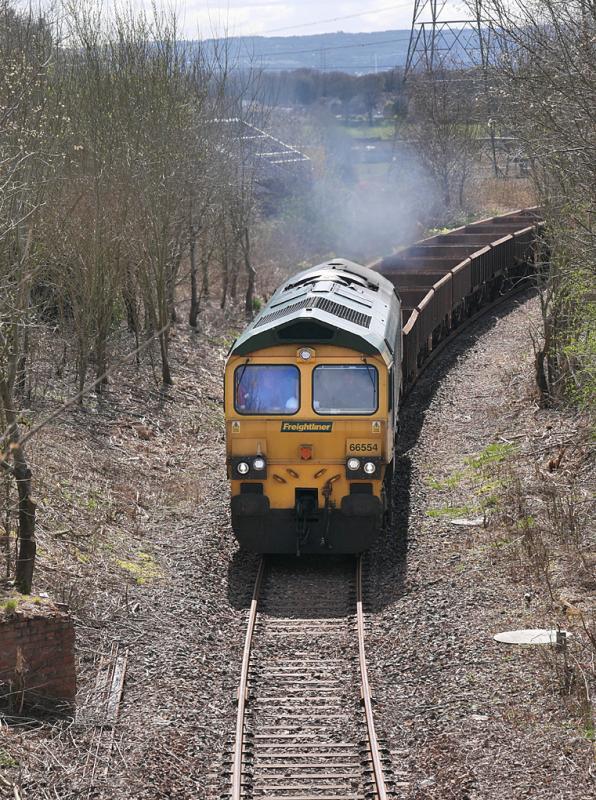 Kilbagie empties: Freightliner 66554 passes the former Kilbagie Mill siding with an empty ballast train from Thornton Junction (Levenmouth Branch) to Ravenstruther on 8 April 2022. Thanks to the driver for the toot. Photo of Kilbagie empties