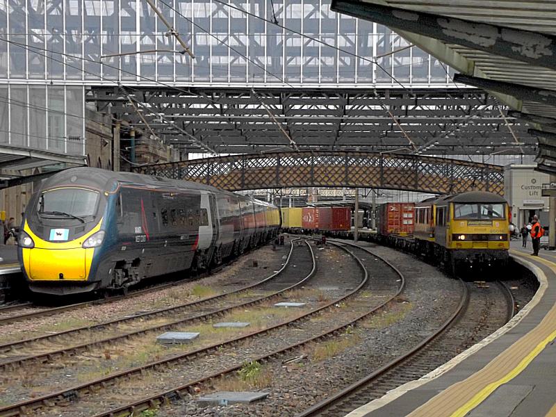 90016 at Carlisle: Green livery Freightliner 90016 leads Orange liveried 90044 at Carlisle with an Intermodal train from Coatbridge to Crewe Basford Hall, on 21st May 2022. On the left Pendolino 390039 waist with a service to London Euston. Photo of 90016 at Carlisle