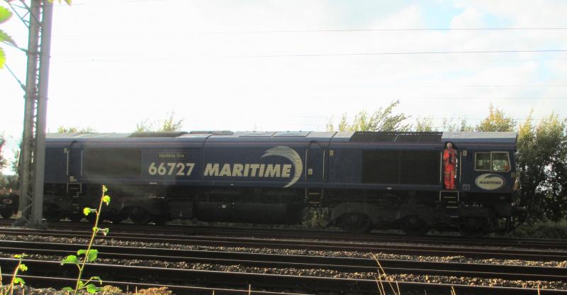 4E69 awaits departure from Malcolm's yard, Elderslie: 66727 on 4E69 waits for a late departure after a late arrival on 23.8.22. The driver obviously wanted a cameo role! Photo of 4E69 awaits departure from Malcolm's yard, Elderslie