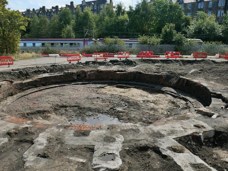 64A turntable pit: Looking over the recently excavated roundhouse turntable pit at St Margarets on a public access event. A Crosscountry voyager passes on the ECML. 27 August 2022. Photo of 64A turntable pit