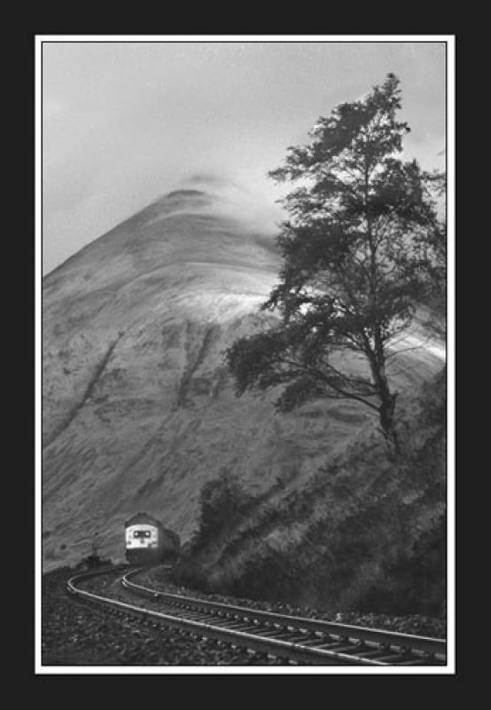 37 at County March: The wind whips the clouds across the summit of Beinn Dorain as an unidentified Class 37 approaches County March with a Glasgow train. Photo of 37 at County March