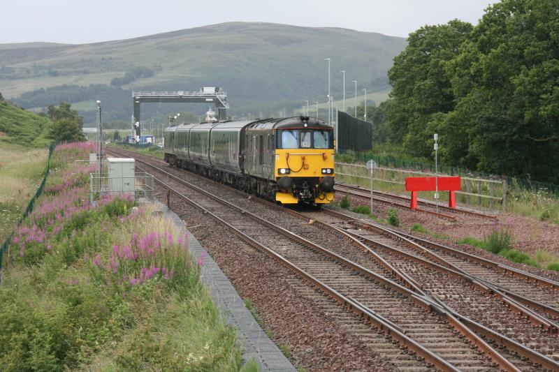 5Z92 at Blackford on 12/07/23: 73971 heads 5Z92 1530 Perth to Polmadie MD past the Highland Spring yard at Blackford with 92018 at the rear Photo of 5Z92 at Blackford on 12/07/23