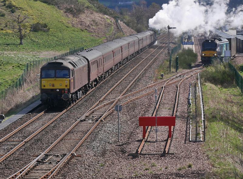Blackford fly-past: 47802 brings up the rear of the 'Great Britain XVI', hauled by 44871 and 45407, as they pass 68018 'Vigilant' waiting in Blackford Freight Terminal. Photo of Blackford fly-past