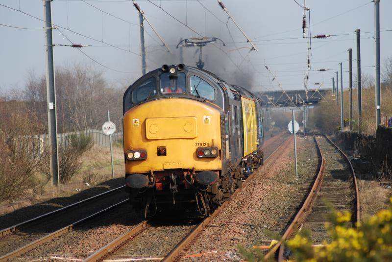 37612 With Mentor @ Stevenson: 37612 Leads test coach Mentor with 37069 smoking on the rear approaching Stevenson Staton
The height of Mentors pantograph is just slightlty higher than the norm Photo of 37612 With Mentor @ Stevenson
