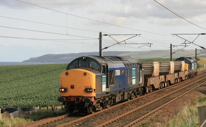 37038 on 6M50 : 37038 leading 37611 waits on the UP line just west of MP 34 3/4 ready to cross over to the Down line with 6M50 Torness to Carlisle. ( A minor road to Oldhamstocks passes under the train ) North Sea is in the background Photo of 37038 on 6M50