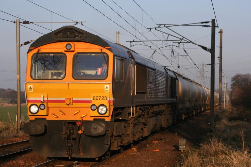 66723 at Gowanhill Farm Road foot crossing: Just short of the foot crossing, 66723 passes over the Curriehill crossover with the Fort William alumina train on 2 March 2011 Photo of 66723 at Gowanhill Farm Road foot crossing