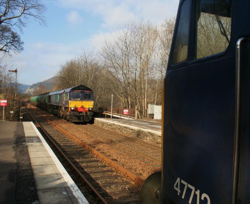 The odd couple at Dunkeld:
An unlikely moment at Dunkeld as 47712 and her crew watches 66433 pass with TTA tanks from Lairg to Mossend Photo of The odd couple at Dunkeld