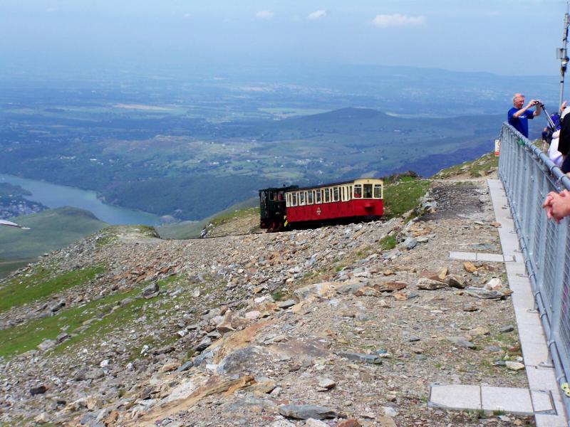 Snowdon rack railway North Wales: An oil-fired loco and coach departing the new top station on Mount Snowdon on a busy wednesday, July 2009 Photo of Snowdon rack railway North Wales