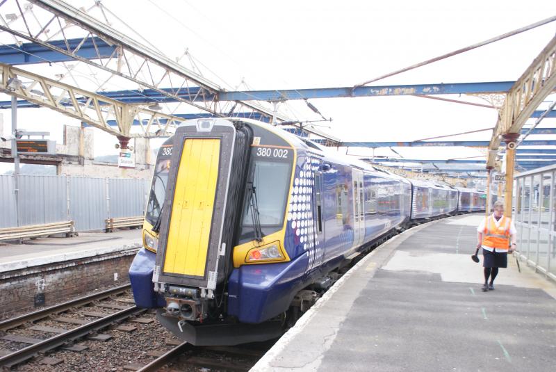 380-Gourock-18th April: The Station Master lady , having put her paddle board up against the train , behind the rear cab to signal the departure , I can only presume that these 380's have no guards. Photo of 380-Gourock-18th April